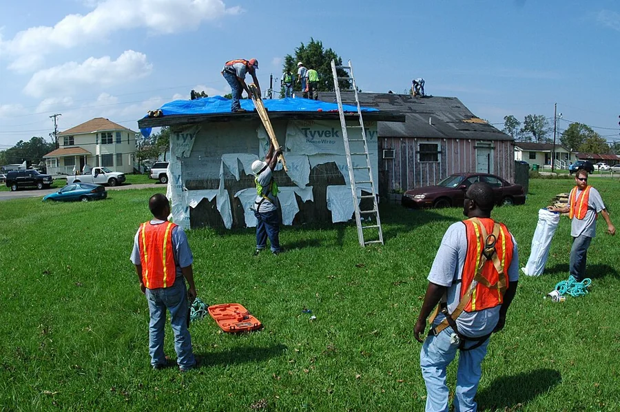 Crew tarping and protecting a storm-damaged roof