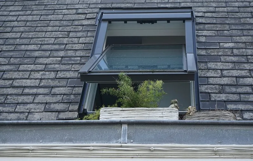 A dormer window set into a shingle roof