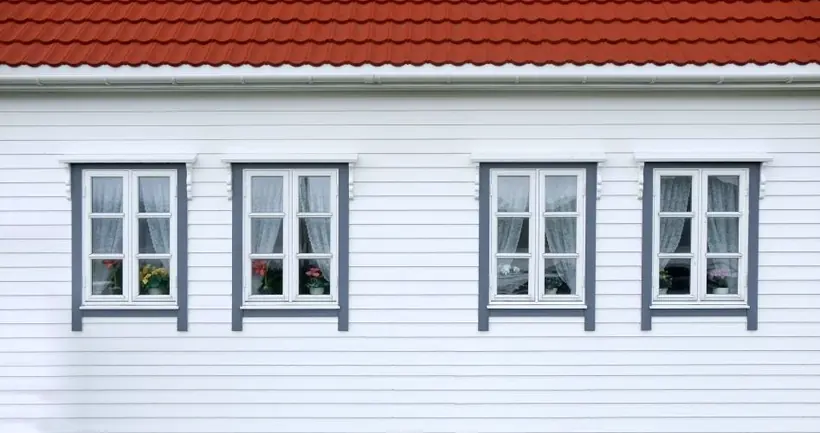 A red tile roof above white siding and windows